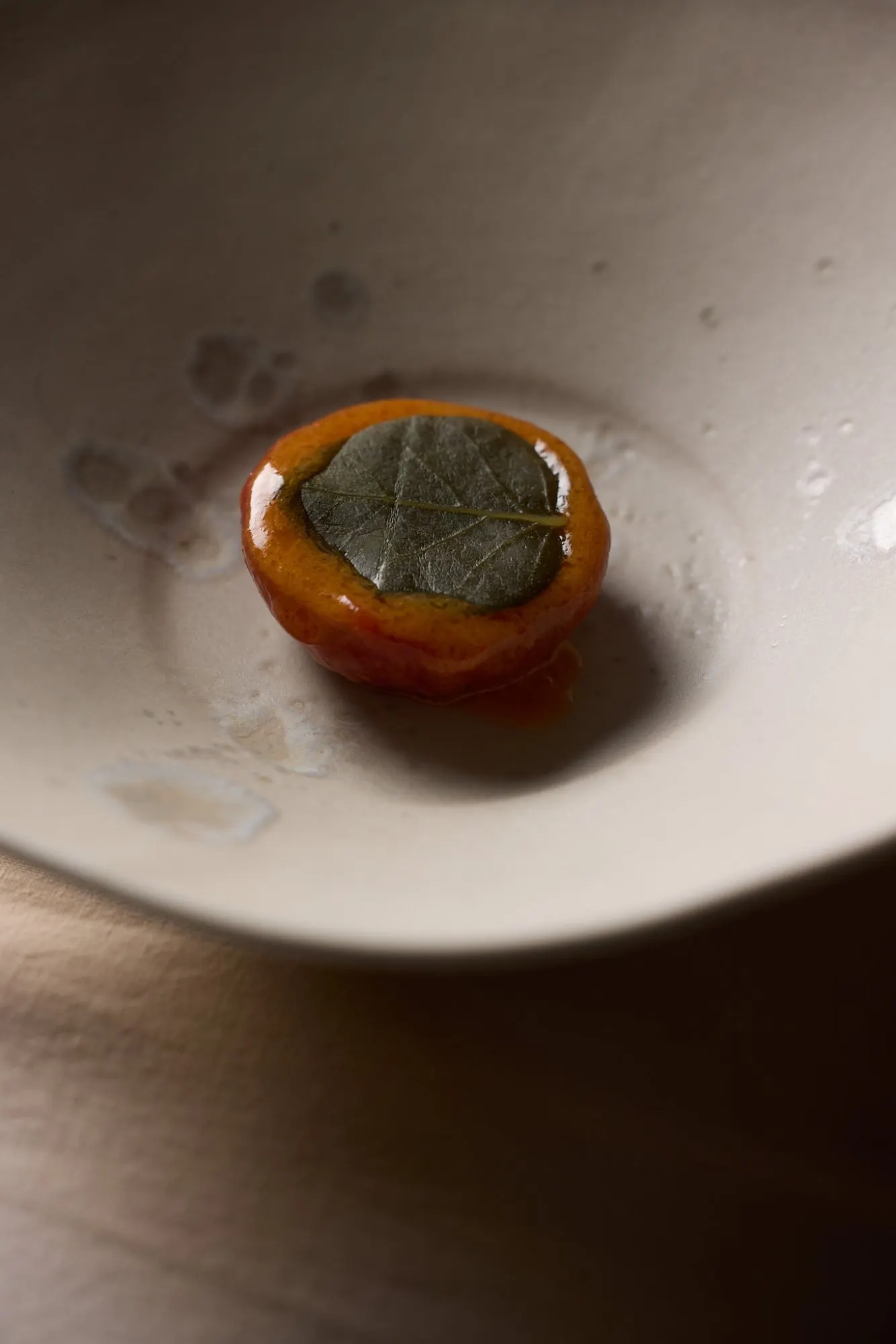 Een gerecht met een glanzende oranje lak in een diep bord