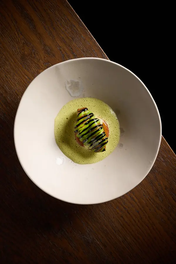 Een groen gerecht op een donkere houten tafel