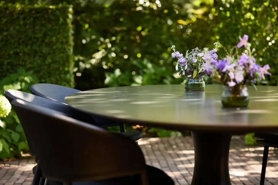 Een tafel met bloemen op het terras in de tuin