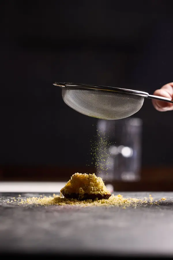 Een gerecht wordt afgewerkt met een fijne zeef