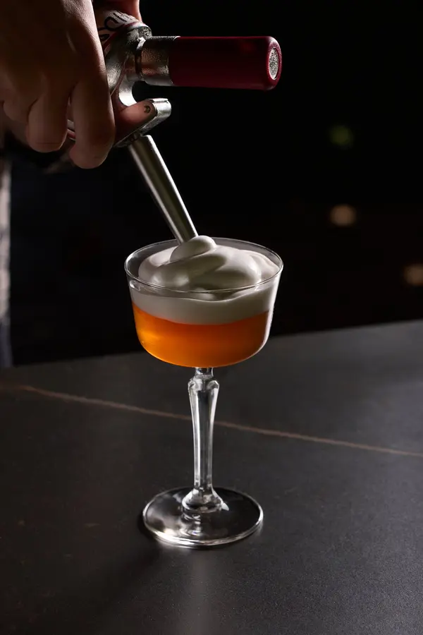 Een cocktail krijgt een schuimkraag uit de sifon
