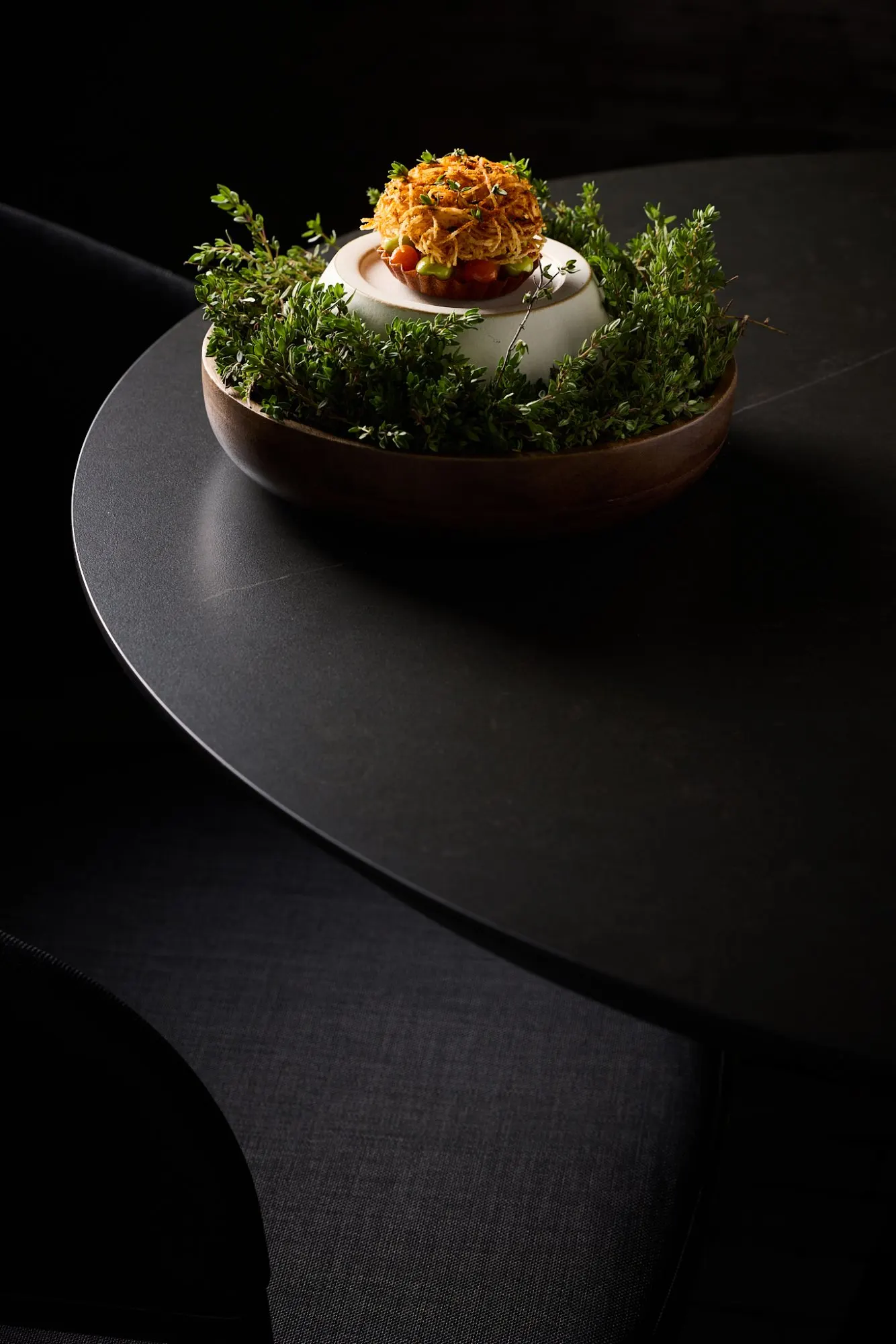 Een gerecht met een krokante garnituur op een donkere tafel
