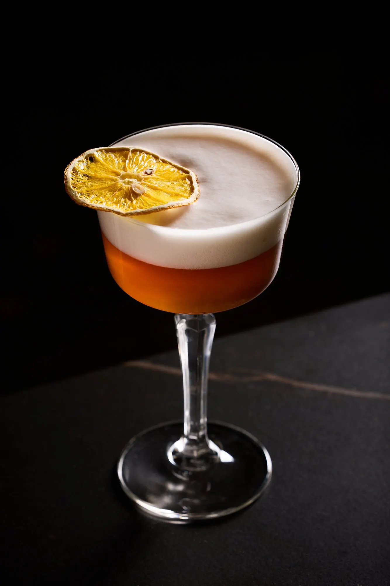 Een cocktail met een gedroogd schijfje citrus